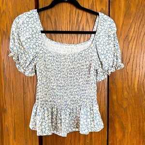 Blue and cream colored fitted blouse.